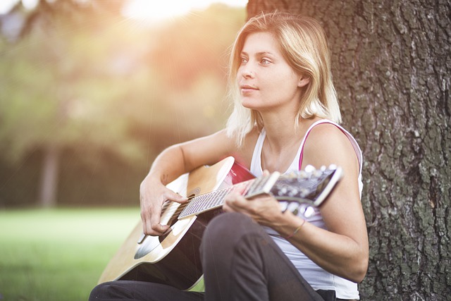 žena hraje na kytaru
